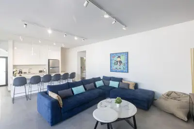 a living room with a blue couch and a kitchen at Protaras Aqua Pearl Villa AQ18 in Protaras