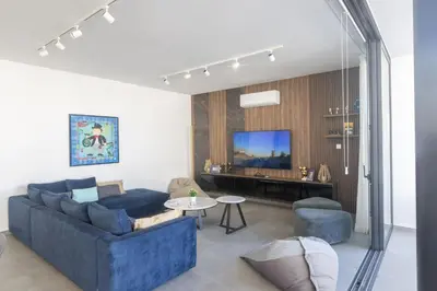 a living room with a blue couch and a tv at Protaras Aqua Pearl Villa AQ18 in Protaras