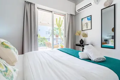 a bedroom with a large white bed and a window at Lazy River 1-Bedroom Apartment in Larnaka
