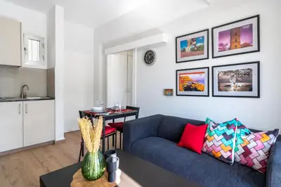 a living room with a blue couch and a kitchen at Lazy River 1-Bedroom Apartment in Larnaka