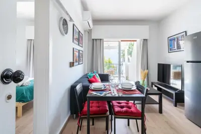 a dining room with a table and red cushioned chairs at Lazy River 1-Bedroom Apartment in Larnaka