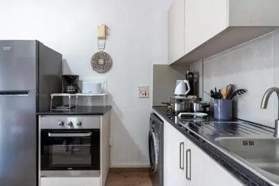a kitchen with a stove and a sink at Lazy River 1-Bedroom Apartment in Larnaka