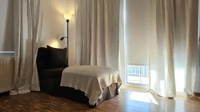 a living room with a chair in front of a window at STAY Aurum Apartment in Nicosia