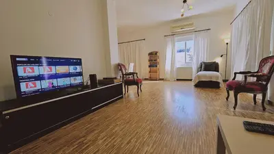 a living room with a flat screen tv and chairs at STAY Aurum Apartment in Nicosia
