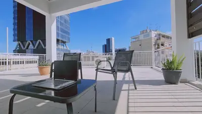 a balcony with a laptop on a table and chairs at STAY Aurum Apartment in Nicosia