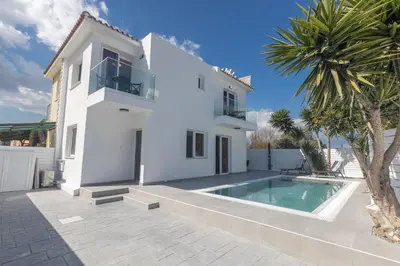 a white house with a swimming pool and a palm tree at Mandali Villa 20 - Fully Renovated Villa in Paralimni