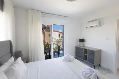a white bedroom with a bed and a window at Mandali Villa 20 - Fully Renovated Villa in Paralimni