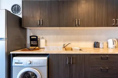 a kitchen with a washing machine and a sink at Snobby 2-Bedroom Apartment in Larnaka