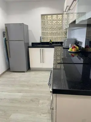 a kitchen with black counter tops and white appliances at Seaview City Retreat in Larnaka