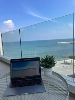 a laptop sitting on a table with a view of the ocean at Seaview City Retreat in Larnaka