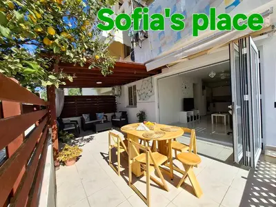 a wooden table and chairs on a patio at Sofia`s place in Voroklini