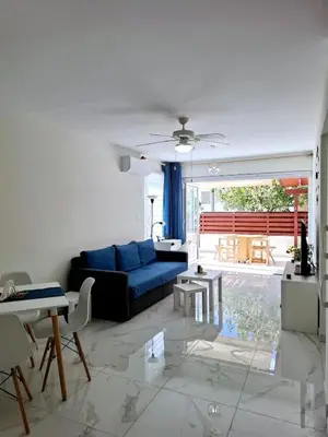 a living room with a blue couch and a table at Sofia`s place in Voroklini