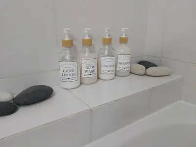 a group of four bottles sitting on a shelf in a bathroom at Sofia`s place in Voroklini