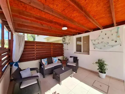 a living room with couches and chairs on a patio at Sofia`s place in Voroklini