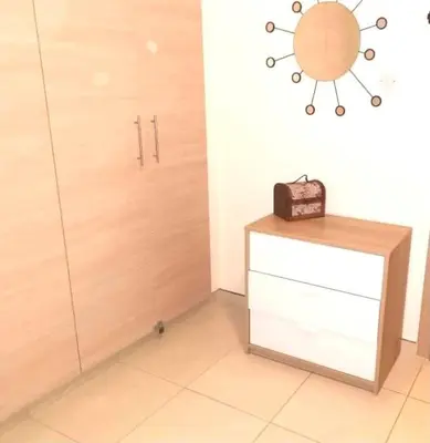 a room with a wooden door and a dresser with a box at Ionian Breeze Family House Walk to Beach And Dining in Paralimni