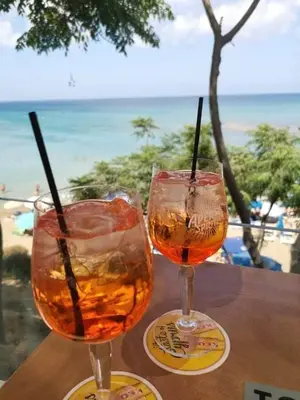 two glasses on a table with a view of the beach at Ionian Breeze Family House Walk to Beach And Dining in Paralimni