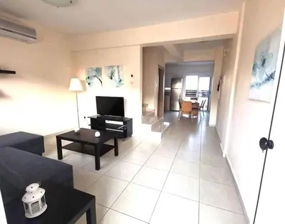 a living room with a couch and a table at Ionian Breeze Family House Walk to Beach And Dining in Paralimni