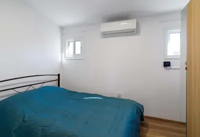 a bedroom with a bed and a air conditioner at Beach Walk - Central, Cool, Cute, Convenient in Limassol