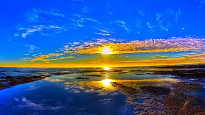 a reflection of the sun in the water at sunset at Beach Walk - Central, Cool, Cute, Convenient in Limassol
