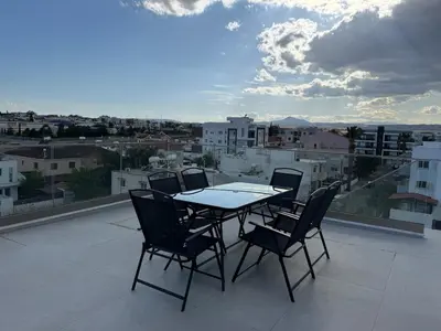 a table and chairs on a balcony with a view at Brandnew Rooftop Flat near Larnaca Mall in Larnaka