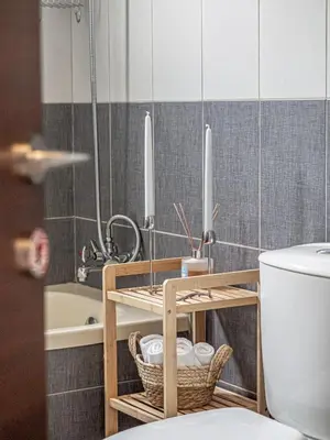 a bathroom with a toilet and a bath tub with candles at Cozy sea view Apartment in Mazotos