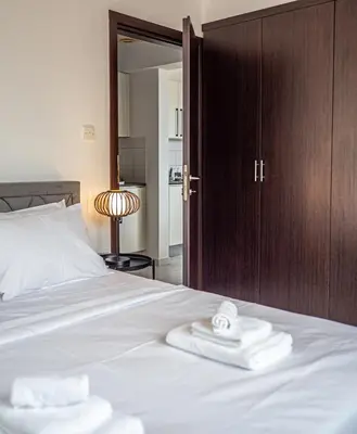 a bedroom with a bed with two folded towels on it at Cozy sea view Apartment in Mazotos