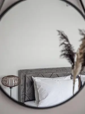 a mirror reflecting a bed with white pillows at Cozy sea view Apartment in Mazotos