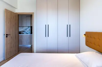 a bedroom with white cabinets and a bed at Stylish Central Apartment • City Views • Prime Location • Parking in Nicosia