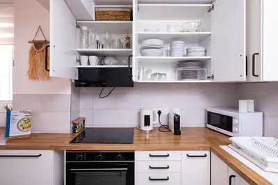 a kitchen with white cabinets and a microwave at Endless Summer Beach House in Pervolia