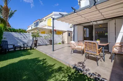 a patio with chairs and a table in a backyard at Endless Summer Beach House in Pervolia