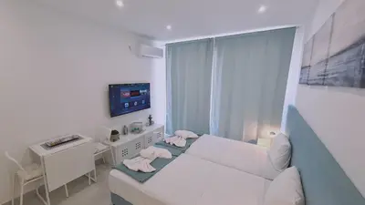 a bedroom with a bed and a desk and a television at STAY Napa Oasis Studio in Ayia Napa