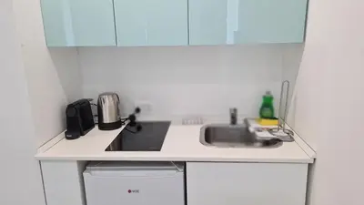 a small white kitchen with a sink and a microwave at STAY Napa Oasis Studio in Ayia Napa