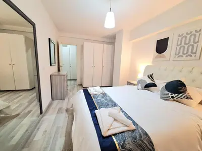 a bedroom with a large white bed with towels on it at Abstract by the Sea in Larnaka