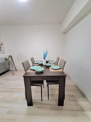 a dining room table with four chairs in a white room at Abstract by the Sea in Larnaka