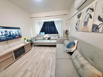 a living room with a couch and a flat screen tv at Abstract by the Sea in Larnaka