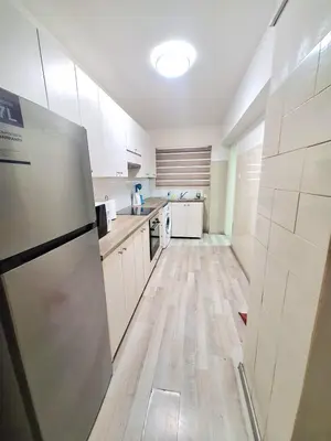 a kitchen with white cabinets and a stainless steel refrigerator at Abstract by the Sea in Larnaka