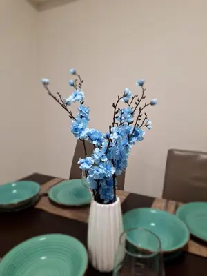 a vase with blue flowers in it on a table at Abstract by the Sea in Larnaka