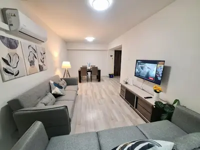 a living room with a couch and a flat screen tv at Abstract by the Sea in Larnaka