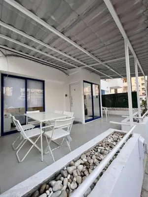 a white room with a table and chairs and rocks at Mandy's apartment in Larnaka