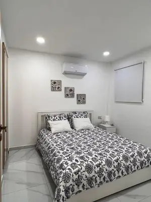 a bedroom with a bed with a black and white comforter at Mandy's apartment in Larnaka
