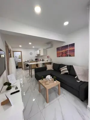 a living room with a black couch and a table at Mandy's apartment in Larnaka