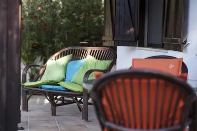 two wicker chairs with pillows on a patio at El Marco Villa in Pissouri