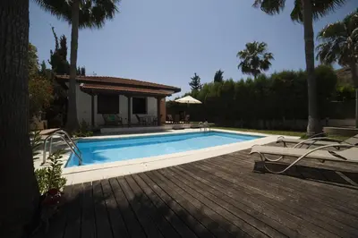 a swimming pool in front of a house at El Marco Villa in Pissouri