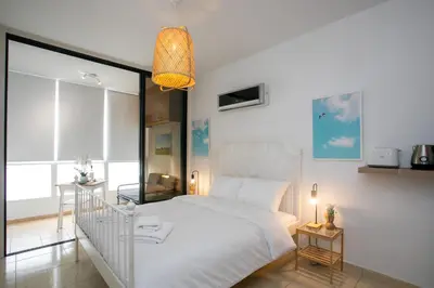 a bedroom with a white bed and a large window at Palmove Makenzy Ria Studio in Larnaka