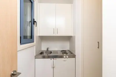 a kitchen with white cabinets and a sink at Niki Seaview Villa DPS27 in Protaras