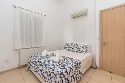 a small bedroom with a bed and a window at Niki Seaview Villa DPS27 in Protaras
