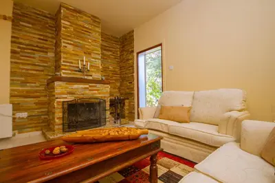 a living room with a couch and a fireplace at VILLa PERSEPHONE in Platres