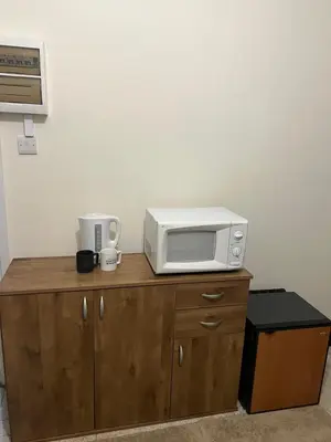 a microwave sitting on top of a wooden cabinet at Enjoy a cozy room in the heart of the capital in Nicosia