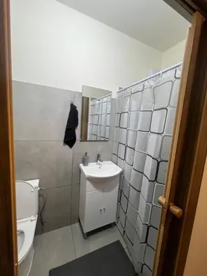 a bathroom with a white sink and a toilet at Enjoy a cozy room in the heart of the capital in Nicosia