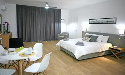 a bedroom with a bed and a table and chairs at Corina Suites & Apartments in Limassol